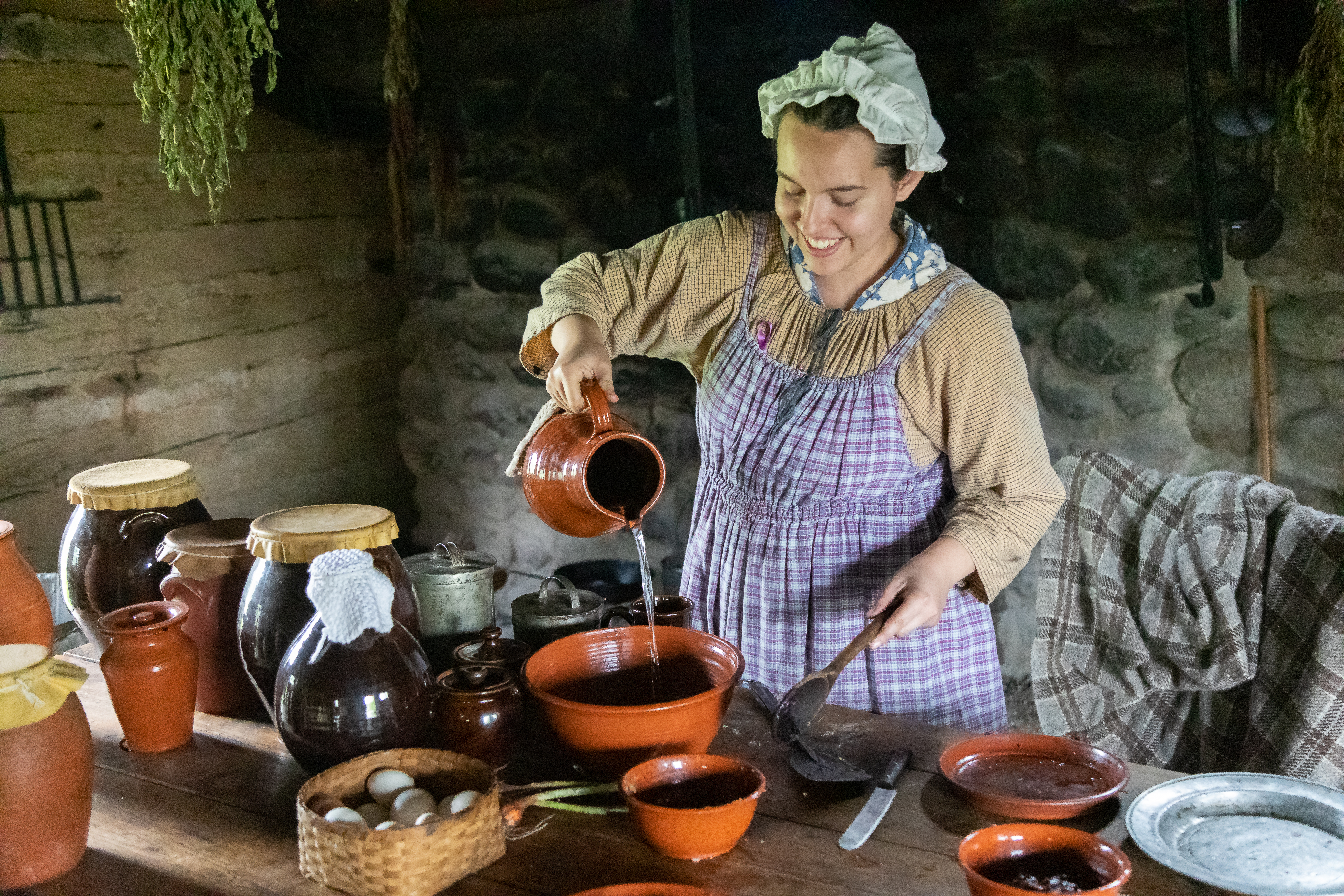 wonman in historical attire working in a kitchen