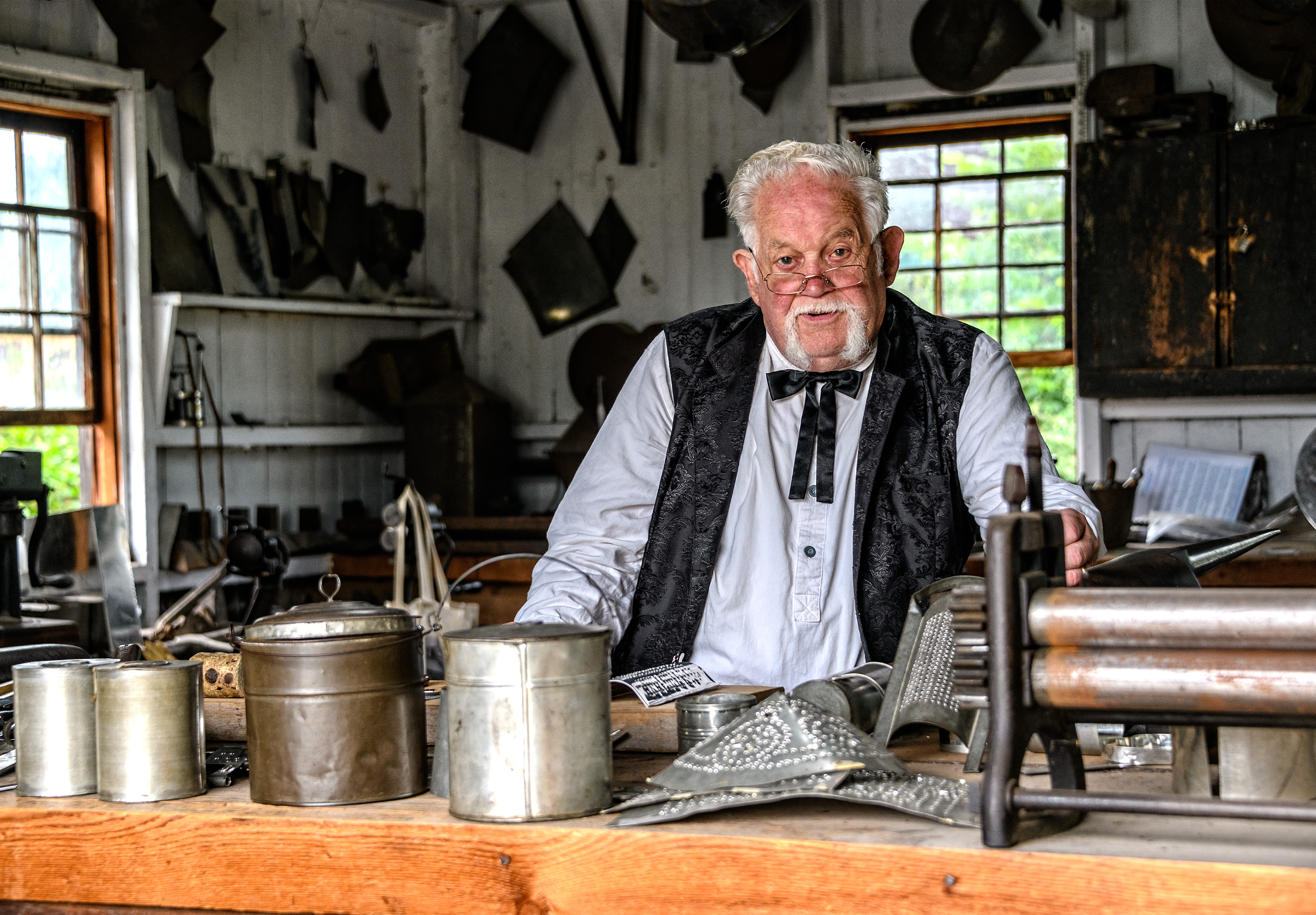 a man in historic attire standing behind a counter