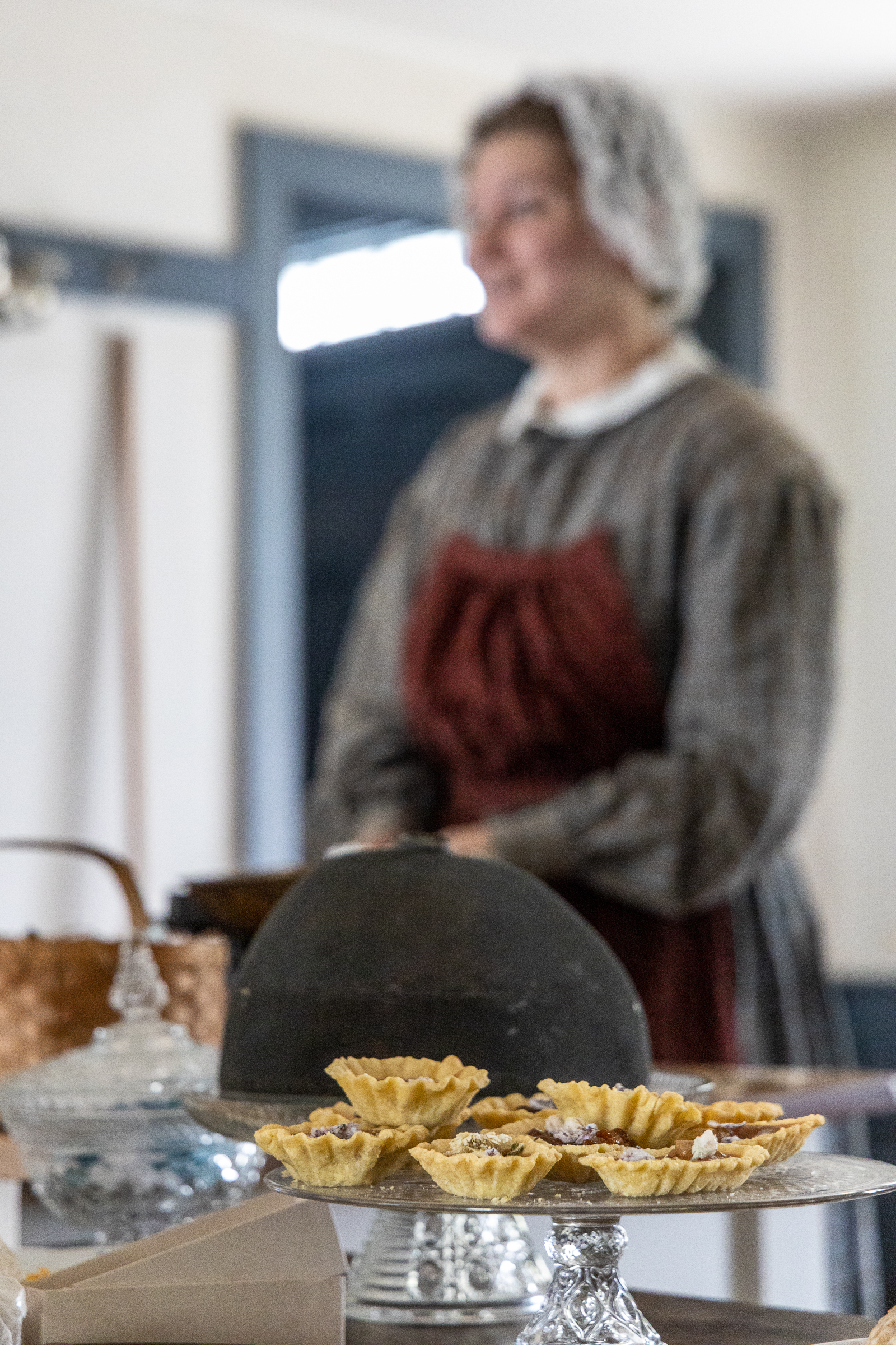 woman in historic attire making confections