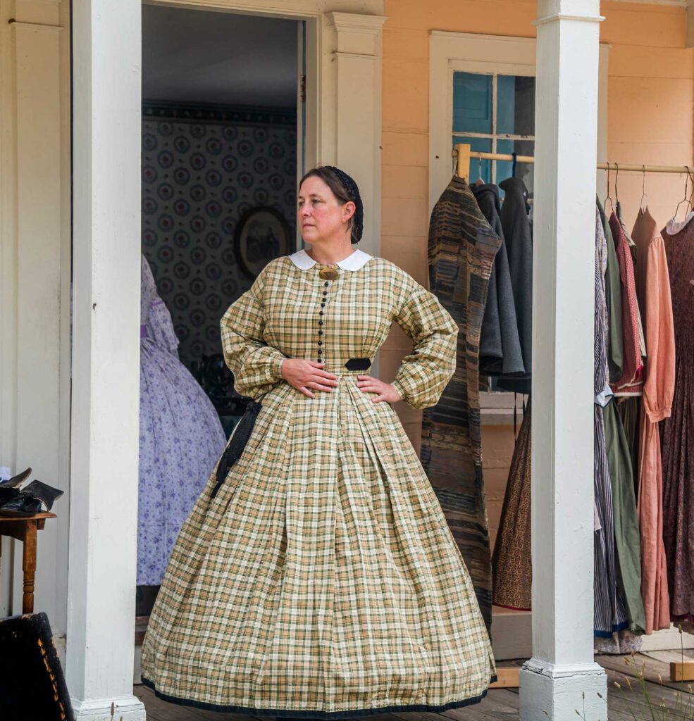 Woman in historic attire standing on a porch