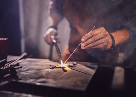 blacksmith working on metal piece