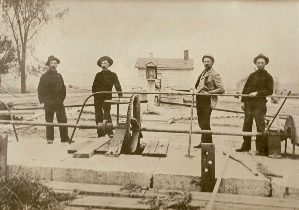 c1880 Erie Canal photo with four men standing outside on a dock